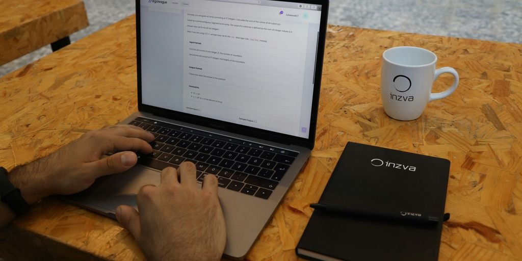 a person sitting at a table with a laptop