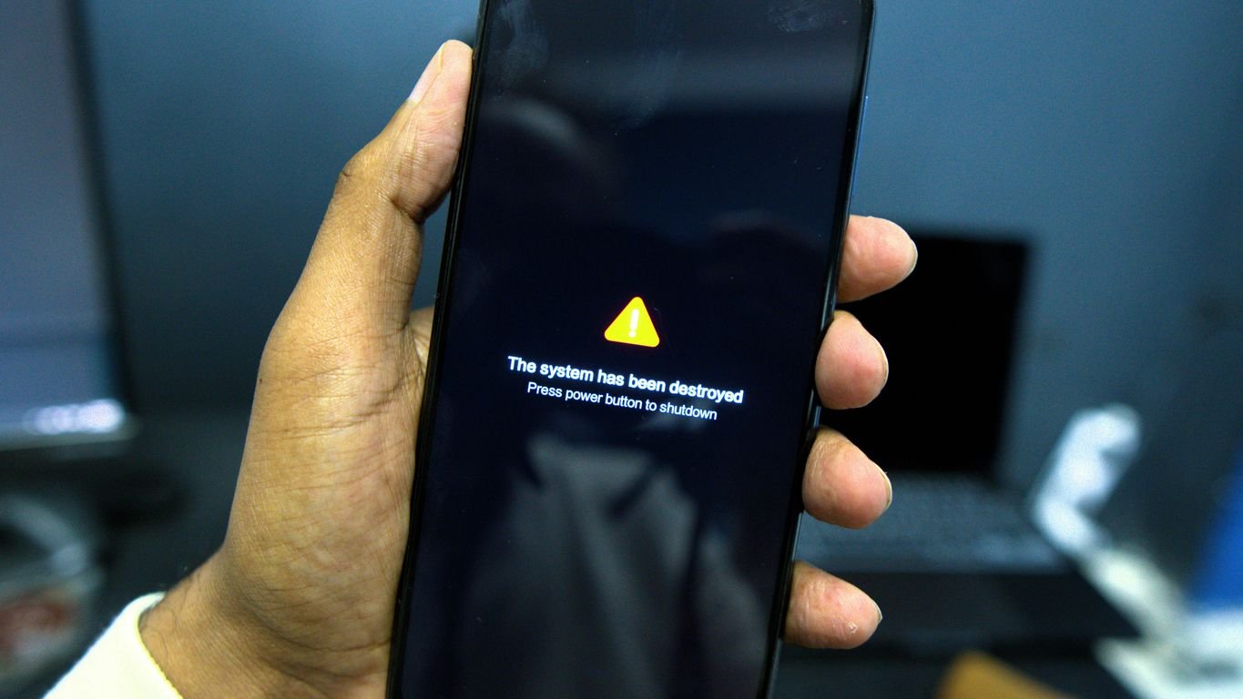Phone shows a system failure warning message.